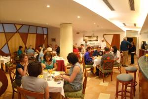 Hotel Due Torri في أَجيرولا: مجموعة من الناس يجلسون على الطاولات في المطعم