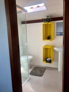 a bathroom with a toilet and a sink with yellow cabinets at Lampião Hostel in Florianópolis