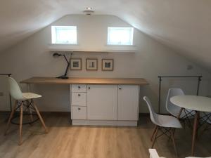 a kitchen with a table and chairs and two windows at Oak Tree Studio in Marlow