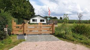 una casa detrás de una valla con una puerta y una valla en 't Nieuwe Nest, en Kaatsheuvel