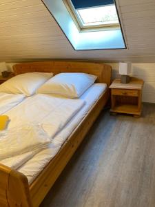 Schlafzimmer mit einem großen Bett und einem Dachfenster in der Unterkunft Ferienhaus Ostseekrabbe in Insel Poel