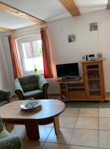 ein Wohnzimmer mit einem Tisch und einem TV in der Unterkunft Ferienhaus Ostseekrabbe in Insel Poel