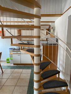 eine Wendeltreppe in einem Zimmer mit einer Küche in der Unterkunft Ferienhaus Ostseekrabbe in Insel Poel