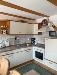 eine Küche mit weißen Schränken und einem Waschbecken in der Unterkunft Ferienhaus Ostseekrabbe in Insel Poel