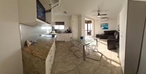 uma cozinha e sala de estar com uma mesa e um sofá em Acushla Accommodation Esplanade Living Self Check-In Self Check-Out em Adelaide