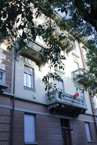 a building with a balcony with a flag on it at MY BED affittacamere in Cuneo