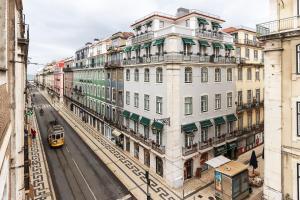 リスボンにあるLisbon Silver Flower - Flat in Lisbon centerのトラムが街路を通り、建物が並ぶ