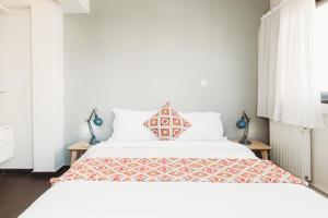 a white bed with a white comforter and pillows at Athens Studios in Athens
