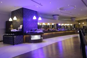 a restaurant with a bar with purple lights at Crowne Plaza Riyadh Palace, an IHG Hotel in Riyadh