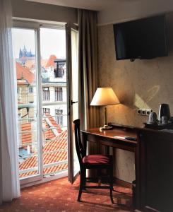a hotel room with a desk and a window at Hotel Rott in Prague