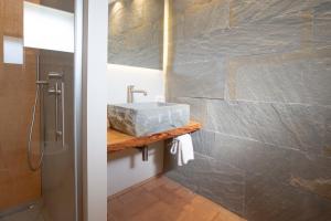 baño con lavabo y pared de piedra en Agriturismo Torre del Marino, en Brisighella