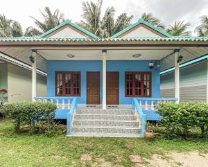 une maison bleue avec des escaliers en face de celle-ci dans l'établissement ศศิธารา การ์เด้นท์, à Sichon