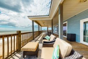 a porch with chairs and a television and the ocean at License to Chill in Dauphin Island