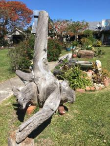 a statue of a tree stump sitting on the grass at Amor Da Vida in Port Elizabeth