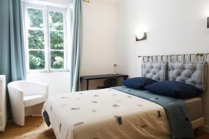 a bedroom with a bed with blue pillows and a window at VILLA EPERONNIERE in Nantes