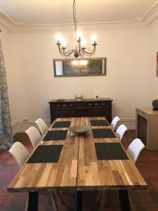 uma sala de jantar com uma mesa de madeira e cadeiras brancas em VILLA EPERONNIERE em Nantes