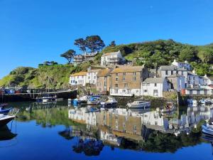a group of boats in a harbor with houses at Penlea Retreat Luxury Coastal Shepherds Hut 5 Minute Walk to Pubs and Village in Polperro