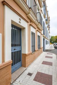 un edificio con una puerta azul en una calle en Alcalá del rio 2B, en Alcalá del Río