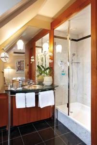 a bathroom with a tub and a sink and a shower at Seaside Park Hotel Leipzig in Leipzig
