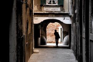 una persona che cammina in un vicolo in un edificio di Ca' dei Armeni - San Marco Square a Venezia