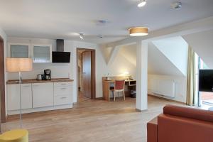 eine Küche und ein Wohnzimmer mit Sofa und Tisch in der Unterkunft Hotel Dirks am Schloss in Bad Pyrmont