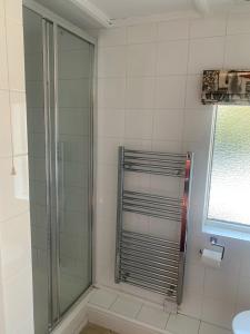 a bathroom with a shower with a glass door at Two Sawyers in Pett