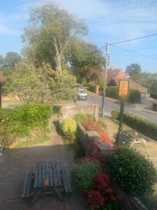 a park with benches and flowers on a street at Two Sawyers in Pett