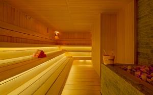 a sauna with a wooden floor and a brick wall at Titanic Deluxe Lara in Lara