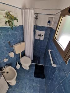 a blue tiled bathroom with a toilet and a sink at Bed & Breakfast SENTIERO 54 in Cantiano