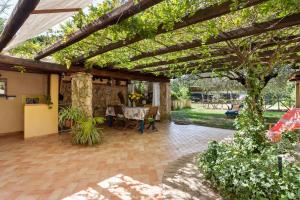 une terrasse avec une pergola en bois et une table dans l'établissement Appartamento Glicine - Villa Teresa, à Bari Sardo