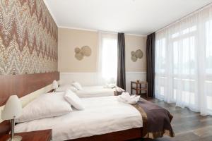 Ein Bett oder Betten in einem Zimmer der Unterkunft Holiday Beach Budapest Wellness Hotel with Sauna Park