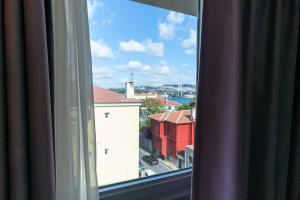 a window with a view of a red building at Malta Bosphorus Hotel in Istanbul