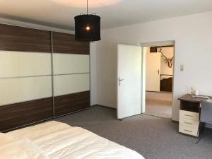 1 dormitorio con cama blanca y espejo en Charmante Stadtwohnung im Zentrum von Leibnitz, en Leibnitz