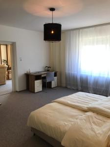 1 dormitorio con cama, escritorio y ventana en Charmante Stadtwohnung im Zentrum von Leibnitz en Leibnitz