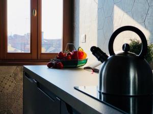 a tea kettle on a counter with a bowl of fruit at Ca' dei Armeni - San Marco Square in Venice