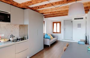 uma cozinha e sala de estar com armários brancos em Ca' dei Armeni - San Marco Square em Veneza