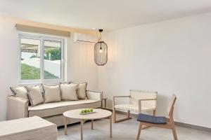 a living room with a couch and a table at Atlantica Marmari Palace in Mastihari