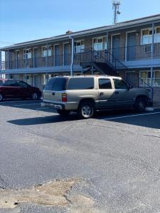 un camión plateado estacionado en un estacionamiento frente a un edificio en Bel Air Motor Lodge, en Maple Shade