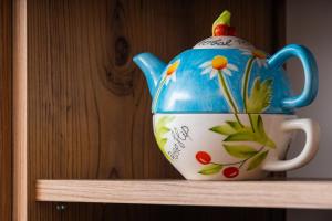 une théière bleue et blanche assise sur une étagère dans l'établissement Sunset Cottage, à Braşov