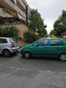 dois carros estacionados num parque de estacionamento ao lado de um edifício em Porta di Roma locazione turistica em Roma