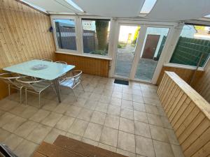 a screened in porch with a table and chairs at Ferienhaus Thalia 1 in Übach-Palenberg