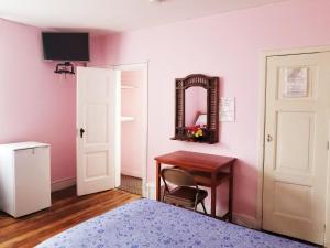 een slaapkamer met een tafel, een spiegel en een bureau bij Travellers Inn in Quito