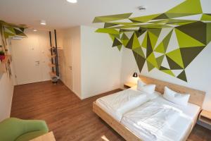 a bedroom with a bed and a geometric wall at Busses Guesthouse in Freiburg im Breisgau