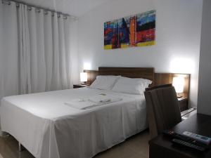 a bedroom with a large white bed with white sheets at Sorrento Suítes Maragogi a 3 min da Orla in Maragogi