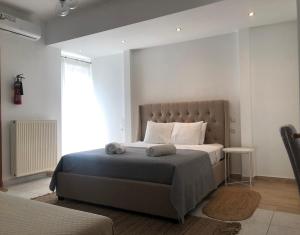 ein Schlafzimmer mit einem großen Bett und einem großen Fenster in der Unterkunft Greece Apartments Now in Patras