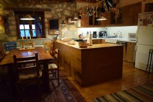 a kitchen with a table and a refrigerator at Arli House in Ano Trikala
