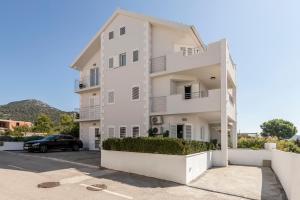 a white building with a car parked in front of it at Hvar de luxe apartments 1 in Hvar