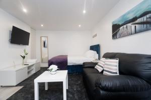 een woonkamer met een bank en een bed bij AMIRI HOUSE APARTMENTs in Leeds