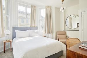 a bedroom with a large bed and a large window at Sonder Kensington Gardens in London