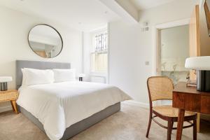 a bedroom with a bed, chair, and a television at Sonder Kensington Gardens in London
